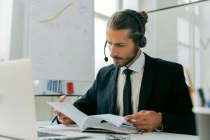 Focused business professional handling customer service tasks with a headset in an office setting.